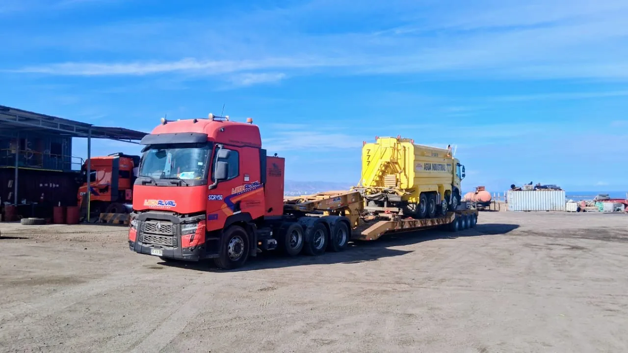 Rampla rebajada transportando camión aljibe