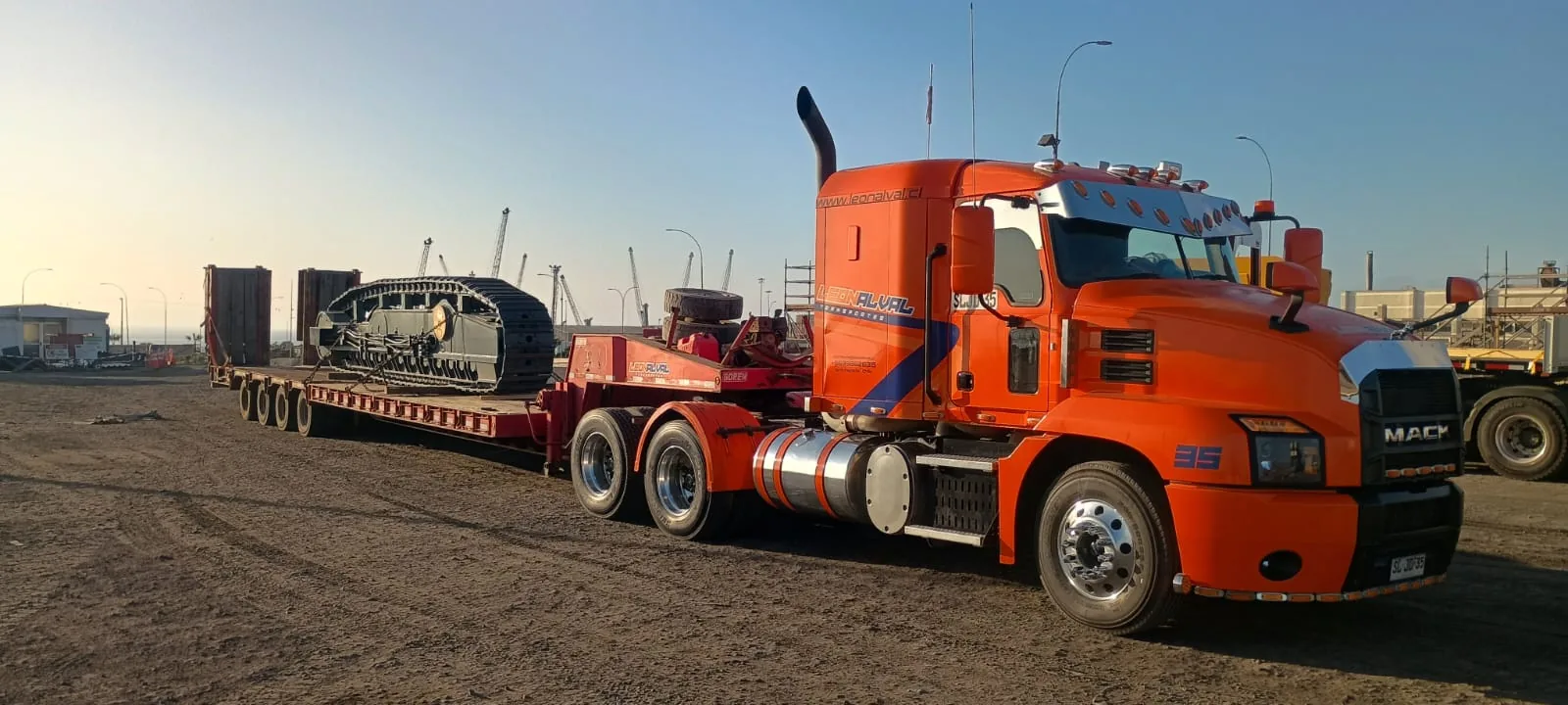 Rampla rebajada transportando maquinaria con orugas